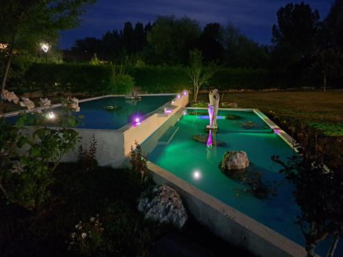 una piscina con luces en un patio por la noche en Prado de las merinas en Caleruega