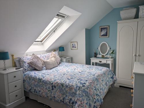 ein Schlafzimmer mit einem Bett mit blauen Wänden in der Unterkunft Village life- Private suite - Living Room, Bedroom and Bathroom in Newtown Saint Boswells