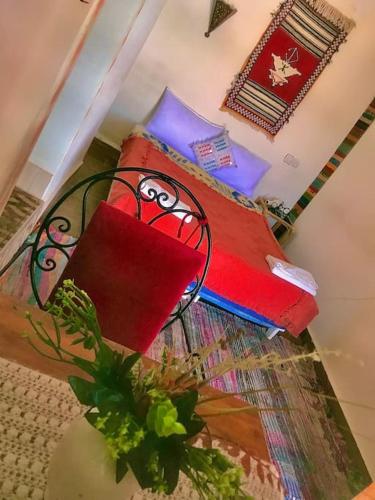 a bedroom with a bed with red and blue pillows at La Kasbah du Jardin in Aït Ben Haddou