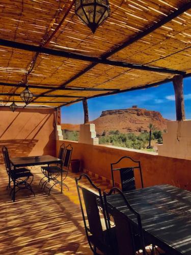 a patio with a table and chairs and a view of a mountain at La Kasbah du Jardin in Aït Ben Haddou