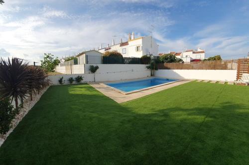 um quintal com uma piscina e uma casa em Vila T2 Algarve piscina privada em Vila Nova de Cacela