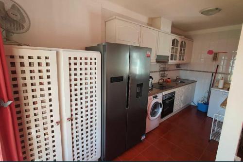 a kitchen with a refrigerator and a washing machine at Vila T2 Algarve piscina privada in Vila Nova De Cacela
