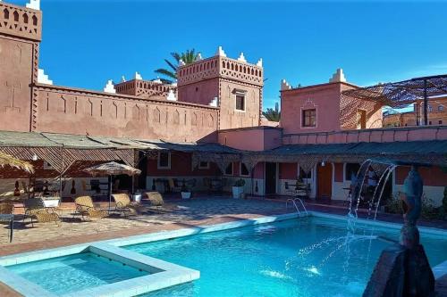 a pool with a fountain in front of a building at La Kasbah du Jardin in Aït Benhaddou