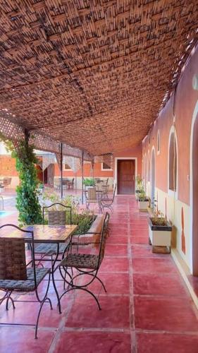 a patio with a table and chairs and a table and chairs at La Kasbah du Jardin in Aït Ben Haddou