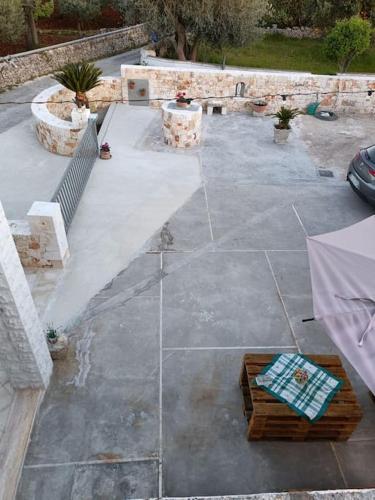 a stone patio with a bench and a table at RosaLilli in Locorotondo