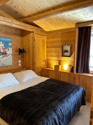 ein Schlafzimmer mit einem Bett in einer Holzhütte in der Unterkunft Nid douillet au cœur de Megeve in Megève