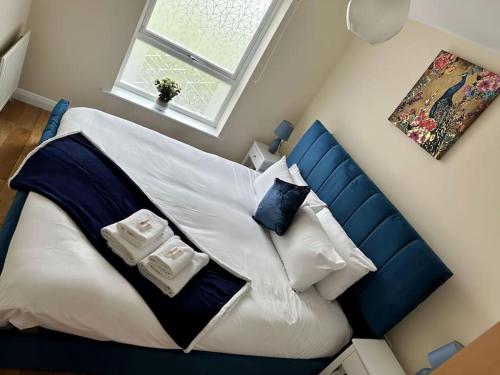 a bedroom with a blue and white bed with pillows at JB Stays Croydon Townhouse in South Norwood