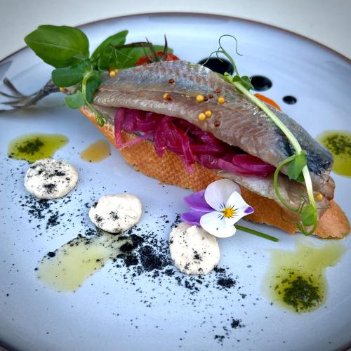 a sandwich with a fish on a white plate at Apartamenty Mesa Grill Restaurant Cafe in Dźwirzyno