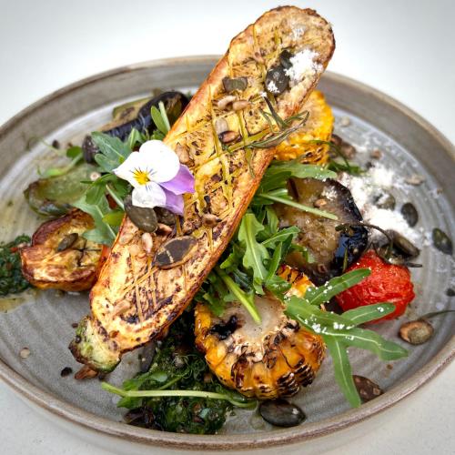 a plate of food with fish and vegetables on it at Apartamenty Mesa Grill Restaurant Cafe in Dźwirzyno