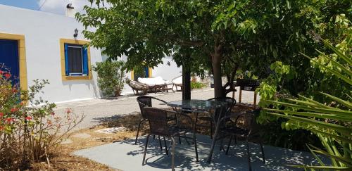 a table and chairs sitting under a tree at LOURANTIANIKA HOUSE in Kýthira