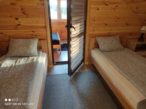 1 dormitorio con 2 camas en una cabaña de madera en Domek Pod Sosnami, en Tomaszów Lubelski