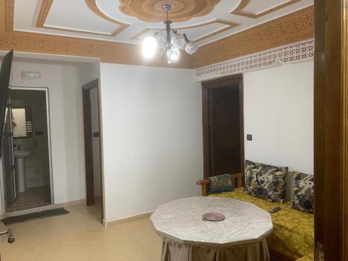 a room with a table and a couch and a ceiling at Appartement familial Al hoceima in Al Hoceïma