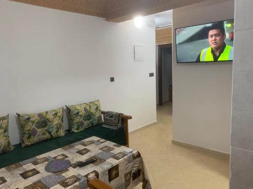 a living room with a couch and a flat screen tv at Appartement familial Al hoceima in Al Hoceïma