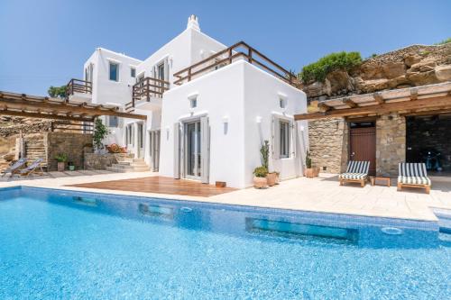 a villa with a swimming pool and a house at Villa Olivia Mykonos in Agios Stefanos