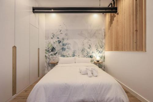 a bedroom with a white bed with two towels on it at MyHouseSpain - Acogedor piso cerca de Atocha I in Madrid