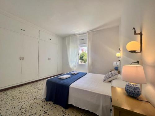 une chambre blanche avec un lit et une fenêtre dans l'établissement Apartamentos Ancora Romana, à Calafell