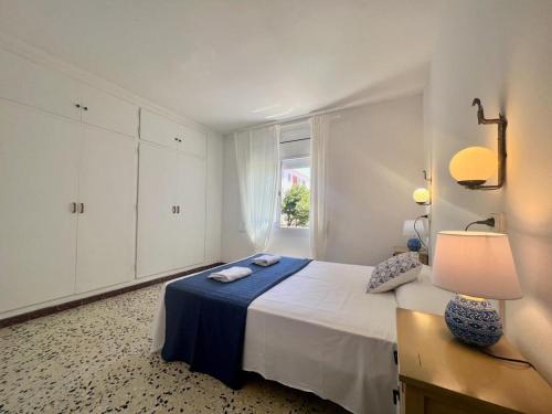 - une chambre blanche avec un lit et une fenêtre dans l'établissement Apartamentos Ancora Romana, à Calafell
