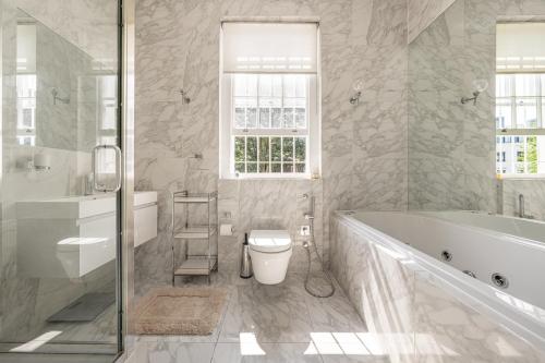 a bathroom with a tub and a toilet and a sink at Luxury 4 bed house in Belgravia Knightsbridge in London