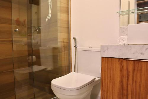 a bathroom with a toilet and a glass shower at Unity #325 - Conforto em Cabo Branco por Carpediem in Penha