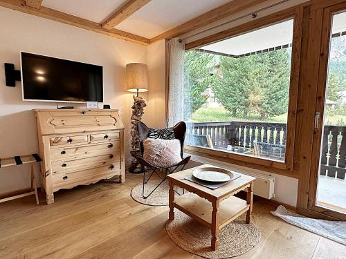 ein Wohnzimmer mit einem TV, einem Stuhl und einem Fenster in der Unterkunft Natur, Erholung, moderne 35m2 für 2P mit Auto PP - SP19 in Pontresina