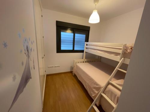 Dormitorio pequeño con litera y ventana en CasaMar en Barbate