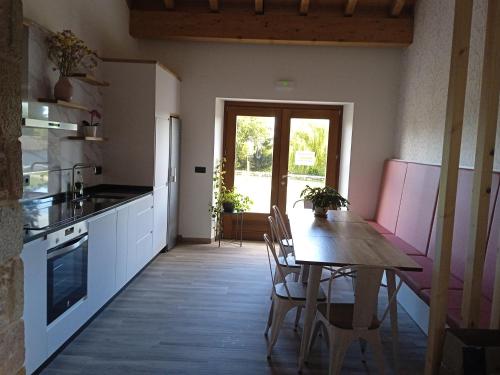 cocina con mesa de madera y comedor en Casona de ventas, en Portomarín