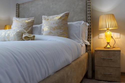 a bedroom with a bed with a lamp on a night stand at 1 bedroom Condo in Westlands with Pool and Gym in Nairobi