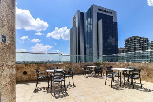 a patio with tables and chairs on a roof at 1 bedroom Condo in Westlands with Pool and Gym in Nairobi