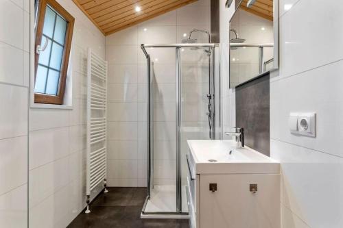 een witte badkamer met een douche en een wastafel bij De Blije Wereld in Otterlo