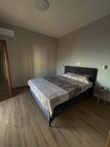 a bedroom with a large bed and a wooden floor at Apart Hotel XXL Lux in Dobra Voda