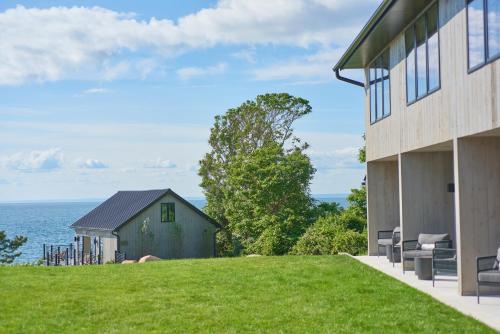 a house with a grassy yard next to a building at Hotel Moraine in Greenport