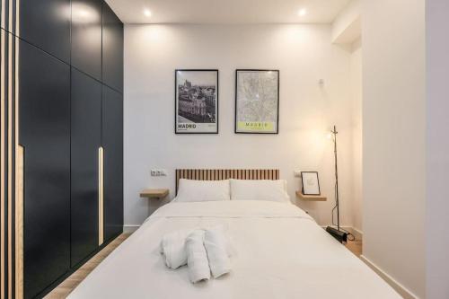 1 dormitorio con 1 cama blanca grande y toallas. en MyHouseSpain - Acogedor piso cerca de Atocha II, en Madrid