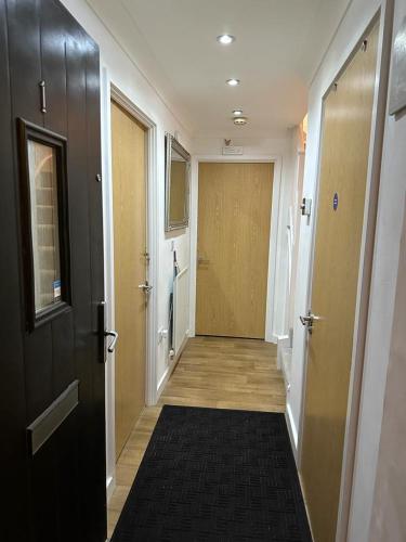 a hallway with a door and a black rug at Dreams Home in Northfleet