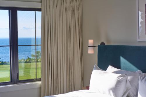 a bedroom with a bed and a large window at Hotel Moraine in Greenport