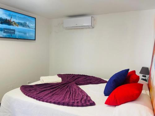 Kerart Lima في أرماساو دي بيرا: غرفة نوم مع سرير أبيض مع وسائد حمراء وزرقاء