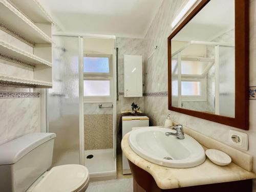 a bathroom with a sink and a toilet and a mirror at Ambient CostaBravaSi in Platja d'Aro