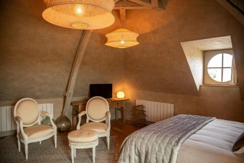 - une chambre avec un lit, des chaises et une fenêtre dans l'établissement La Maison d'Horbé, à La Perrière