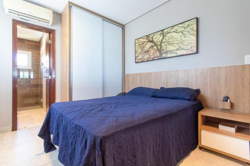 Un dormitorio con una cama azul y una ventana en Mansão Falésias #480 - Paraíso ao Mar da Praia de Sibaúma por Carpediem en Tibau do Sul