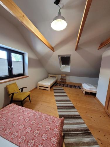 an attic room with a bed and a couch at Dom we wsi - Wioska Mnicha in Knyszyn