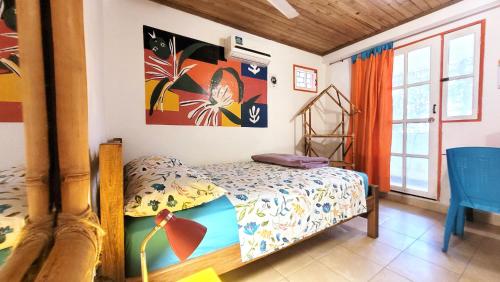 a bedroom with a bed and a table at Divanga Hostel and Diving in Taganga