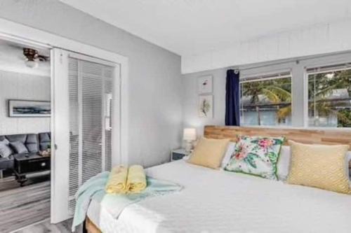una camera da letto con un grande letto bianco e due finestre di Olive Studio Apart Unit 3 By Pmi a West Palm Beach