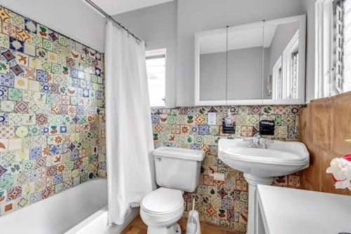 Olive Studio Apart Unit 3 By Pmi في ويست بالم بيتش: حمام مع مرحاض ومغسلة وحوض استحمام