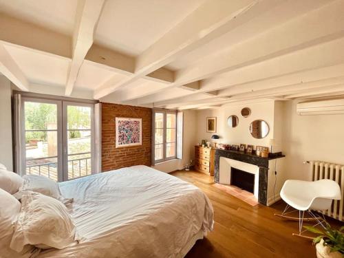 - une chambre avec un grand lit et une cheminée dans l'établissement Superbe duplex climatisé place St Etienne, parking, à Toulouse