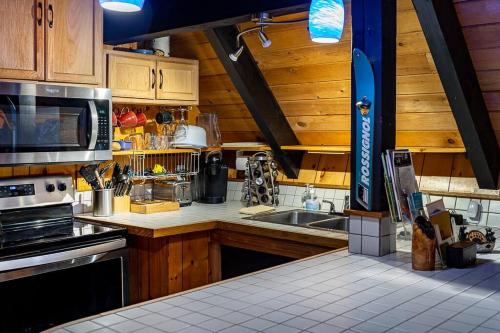 a kitchen with a sink and a stove top oven at Retro A-Frame Cabin - Firepit & Fireplace in Skykomish