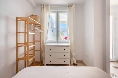 ein Schlafzimmer mit einem Bett, einer Kommode und einem Fenster in der Unterkunft Casa de pescadores - Primera línea de playa in Valencia