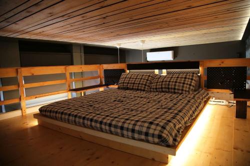 a bed with a checkered blanket in a room at Piccu Go in Pisogne