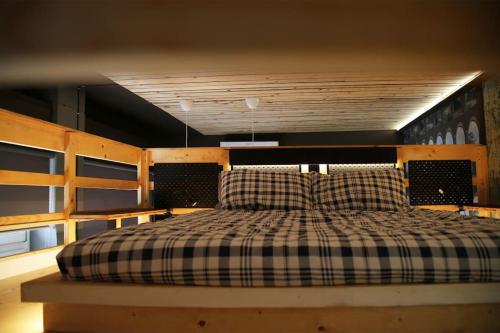 - une chambre avec un lit et une couverture en damier dans l'établissement Piccu Go, à Pisogne