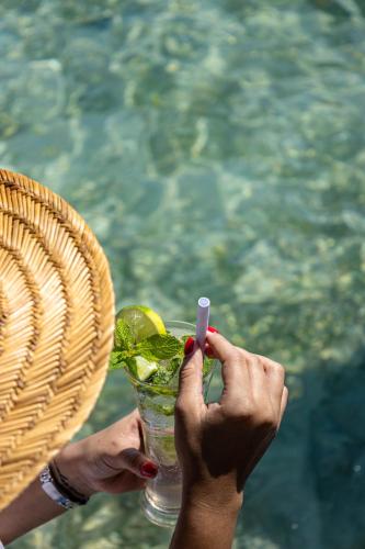 a person is holding a drink with a cigarette at Fragata Island House in Isla Grande