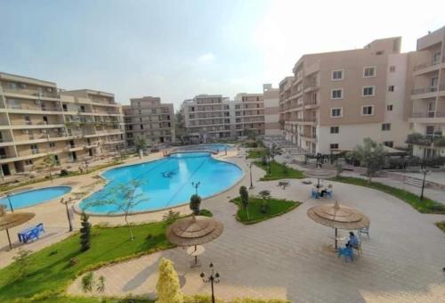 an aerial view of a large swimming pool with apartment buildings at Pyramids and Museum Resort Apartment in Giza