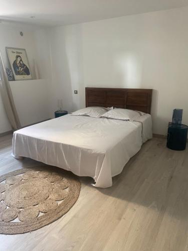 - une chambre avec un grand lit blanc et un tapis dans l'établissement Casa santa, à Monticello